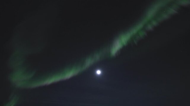 Timelapse view of green aurora with full-moon dancing over Malangen Fjord