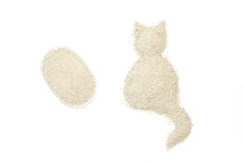 Silhouette of a cat created from fine small granules of cat litter and transparent container with granules on a white background. Pet care