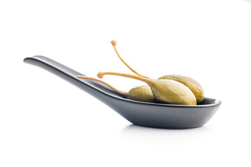Pickled capers berries on scoop isolated on white background.