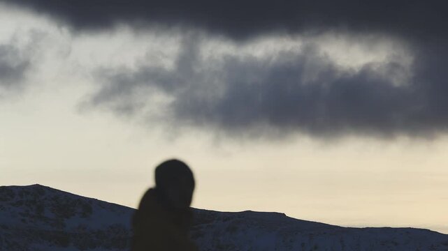 Man stands on the final rock above wild Arctic scenery in Northern Norway, alone with his thoughts