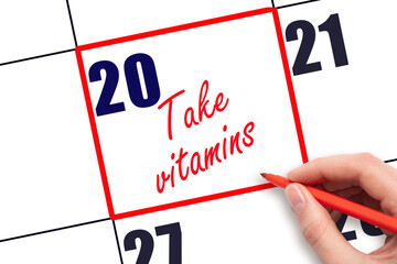 20 th day of the month.  Hand writing Take vitamins reminder and drawing red frame on calendar with red pen on white background. concept of health care. Planning and scheduling