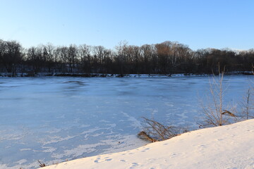 Frozen Lake with Snow-Covered Shores and Sunlit Trees on Distant Bank &mdash; Winter Landscape