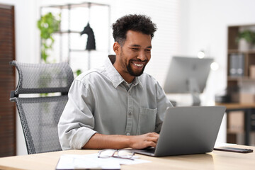 Fototapeta premium Man working on laptop at table in office