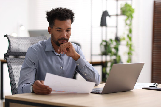Man with document working at table in office