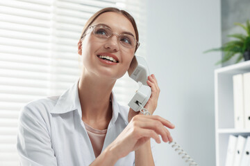Professional nurse talking on telephone in clinic, space for text