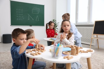 Cute children at white tables during lesson in elementary school
