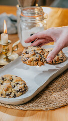 A person is holding a cookie on a plate