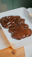 A white dish with two pieces of chocolate cake in it