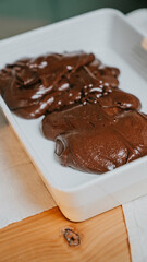 A white dish with chocolate sauce on it