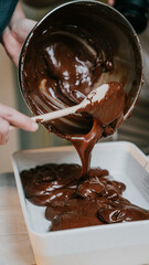 A person is pouring chocolate into a pan