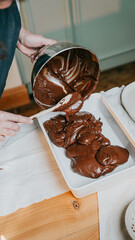 A person is pouring chocolate into a pan