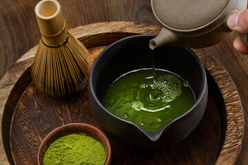 Traditional Matcha Preparation. High-angle view of matcha tea being prepared with a bamboo whisk