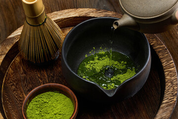 Traditional Matcha Preparation. High-angle view of matcha tea being prepared with a bamboo whisk