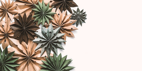Eco Christmas paper ornaments from kraft and recycled paper &mdash; origami stars in green and natural tones, minimalist flat lay for sustainable holiday decor, zero-waste concept