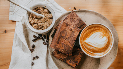 A plate of brownies and a cup of coffee with a heart on top