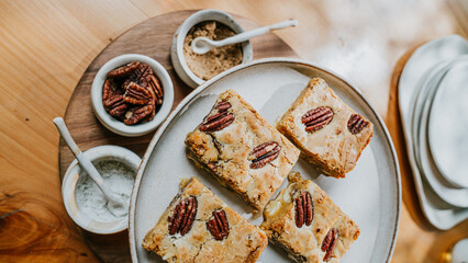 A plate of four peanut butter bars sits on a wooden table