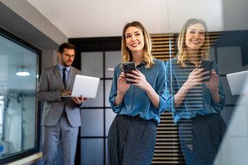 Busy smiling executive business team using digital devices in office. Diverse professional people