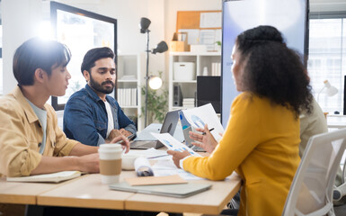 Fototapeta premium Multi-ethnic business team in office meeting, reviewing documents and brainstorming innovative ideas for a new business venture and strategy.