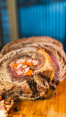 Juicy stuffed beef ribs with calabrese sausage, bacon and vegetables. Golden brown and perfectly cooked, tied with twine. Ideal for gourmet menus and meat promotions.