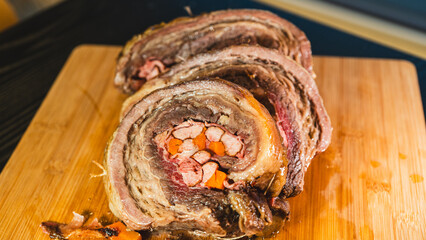 Juicy stuffed beef ribs with calabrese sausage, bacon and vegetables. Golden brown and perfectly cooked, tied with twine. Ideal for gourmet menus and meat promotions.