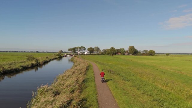 Drone flight over Dutch polder path toward Eemnes harbor