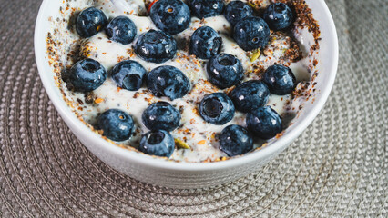 Healthy yogurt bowl topped with fresh blueberries and mixed seeds. Nutritious breakfast or snack for a balanced diet and active lifestyle. Simple and delicious.