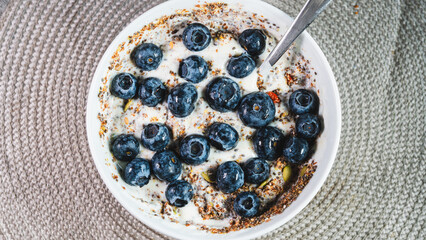 Healthy yogurt bowl topped with fresh blueberries and mixed seeds. Nutritious breakfast or snack for a balanced diet and active lifestyle. Simple and delicious.