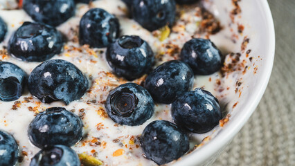 Healthy yogurt bowl topped with fresh blueberries and mixed seeds. Nutritious breakfast or snack for a balanced diet and active lifestyle. Simple and delicious.