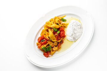 Tagliatelle pasta with cherry tomatoes, garlic, basil, and burrata cheese on a white plate. Italian cuisine, fresh ingredients, elegant restaurant-style presentation.