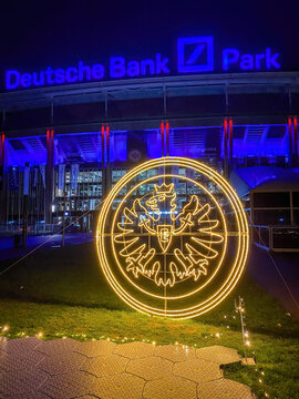 Frankfurt, Germany - December 5, 2022: Eintracht Frankfurt's glowing eagle emblem lit up in front of Deutsche Bank Park at night