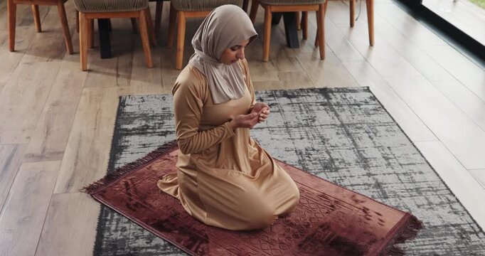 Pray, woman and dua in home for muslim religion, worship and praise to Allah with forgiveness. Spiritual, faith and person with hands cupped in islam for peace, hijab and prayer on mat in house