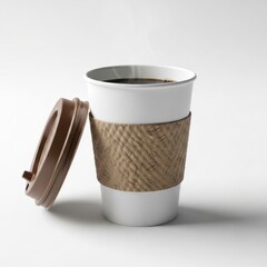 A white disposable coffee cup with a textured brown sleeve and lid sits on a white surface