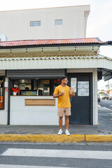 Young man enjoying street food outside a casual local restaurant