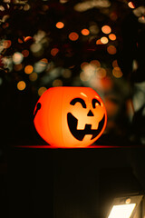 Bright Orange Plastic Jack-o'-Lantern with Bokeh Background