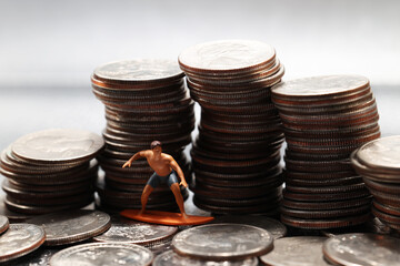Tiny man figurine surfing a wave of quarters