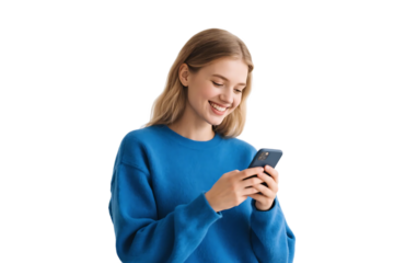 A young woman in a blue sweater is happily using her mobile phone, engaged in digital communication.