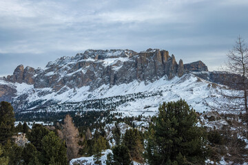 Panoramic view across the Dolomites in winter with the Sella Massif against cloudy sky