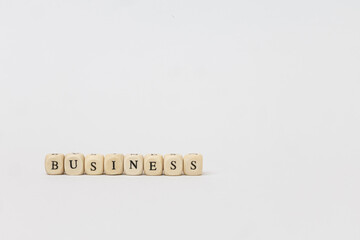 Business concept displayed with wooden blocks spelling out 'BUSINESS' on a clean, minimalistic background emphasizing professionalism and clarity. copy space