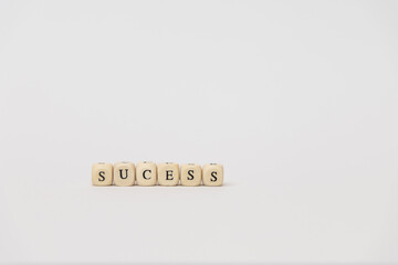 Wooden blocks spelling out the word success on a minimalistic background, symbolizing achievement and personal growth in business. copy space