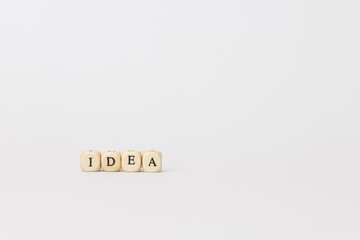 Wooden blocks spelling out the word idea on a minimalistic background, symbolizing creativity and inspiration in a modern workspace. copy space