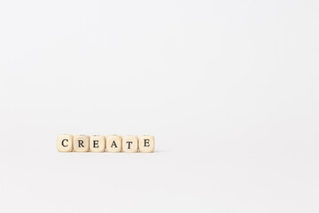 Wooden blocks spelling create on a minimalistic background, symbolizing innovation, creativity, and the power of imagination in design. copy space