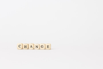 Wooden blocks spelling out the word change on a minimalistic white background, symbolizing transformation and innovation in finance and technology. copy space