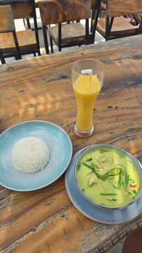 Enjoy a delicious and aromatic Thai Green Curry served with rice and a refreshing beverage Koh Samui Thailand