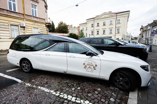 White Mercedes Benz funeral car in Tarnow Poland with crest logo on door for hire