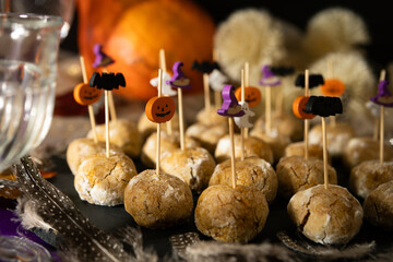 Halloween dessert table with pumpkin treats, witch hats, bats, ghosts, and vibrant autumn...