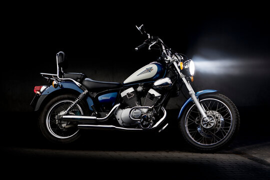 Yamaha Virago 125. Classic motoring. A chopper-style motorcycle, visible from the side at night, as if riding in fog. Stylish lighting on the chrome elements.