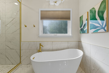Bathroom with a gold framed shower and a white bathtub