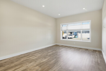 Large, empty room with a window and a white wall