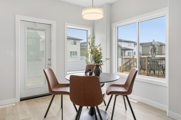Table with four chairs and a vase of flowers in the center