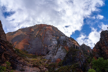 Towering sandstone cliffs under a dramatic cloudy sky.